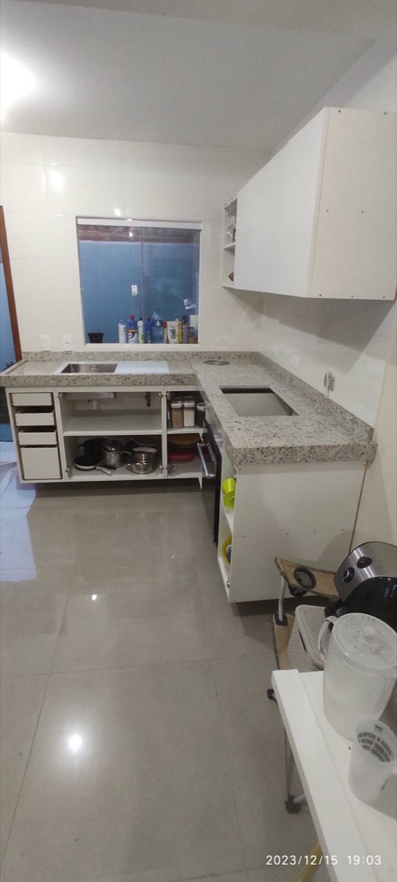 Bancada de granito claro em cozinha em L, com fogão e pia embutidos